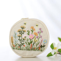 Hand embroidered jewelry pouch in cream linen with colorful wildflower and bee embroidery