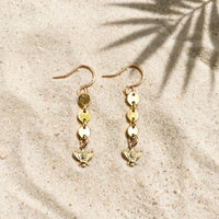 Bee Charm Coin Earrings in 14k gold fill, styled on pale sand at the beach