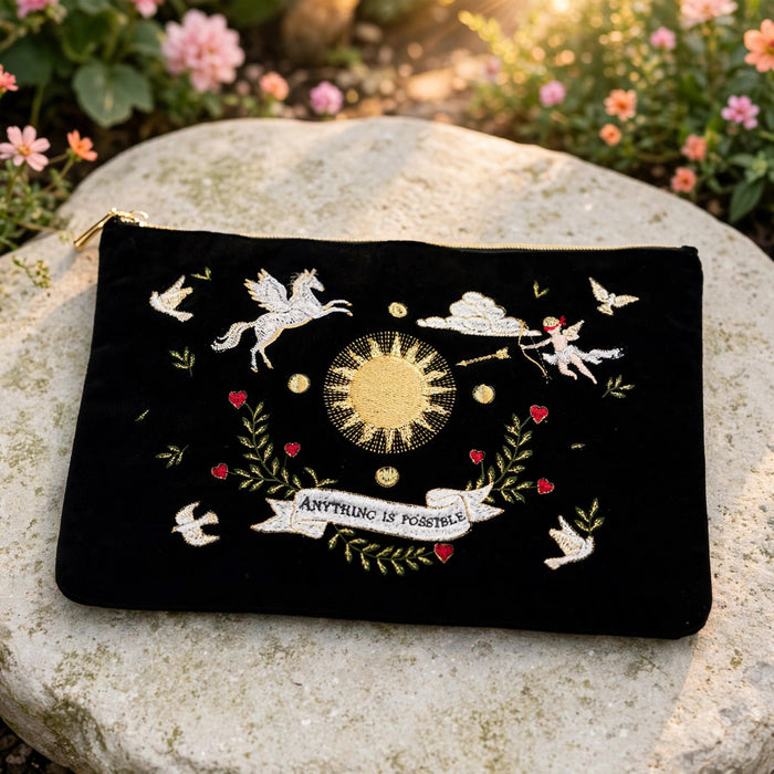 Black Celestial Velvet Embroidered Pouch in a sunlit garden