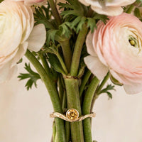 Current ring with citrine in solid 14k gold around a bundle of ranunculus and anemone stems