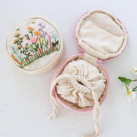 Hand embroidered jewelry pouch open, showing the drawstring inner pouch