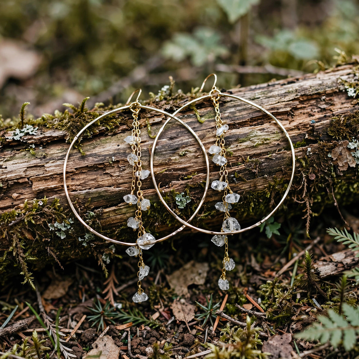 Enchanted Herkimer Diamond Earrings in 14k gold fill with dangling herkimer diamond quartz crystals, resting on a mossy branch