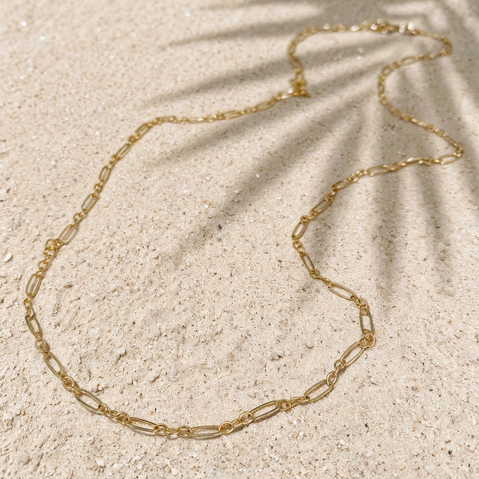 Everyday Layering Chain Necklace in 14k gold fill, styled on pale sand at the beach