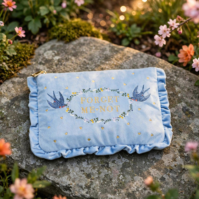 Forget Me Not Blue Velvet Embroidered Pouch in a sunlit garden