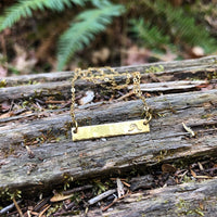 Hand Stamped Bar Necklace in 14k gold fill with a wave-stamped bar pendant, styled on driftwood