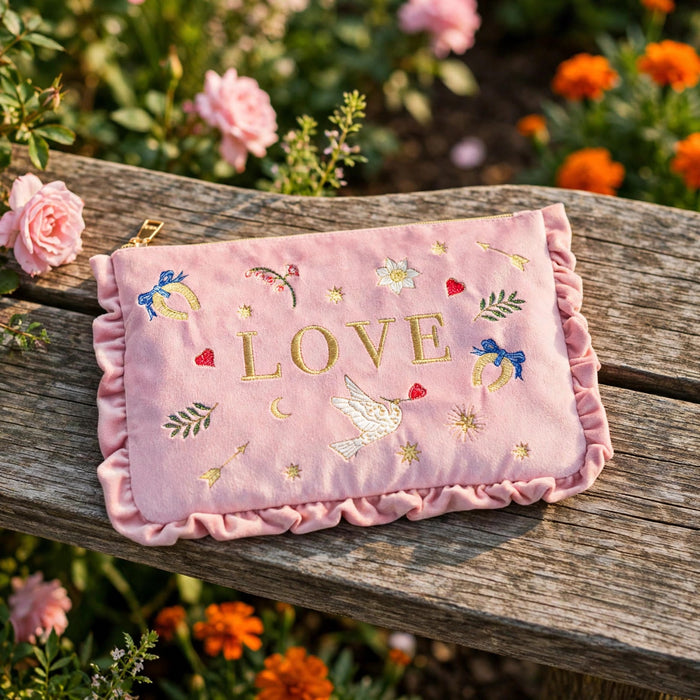 Love Notes Pink Velvet Embroidered Pouch in a sunlit garden