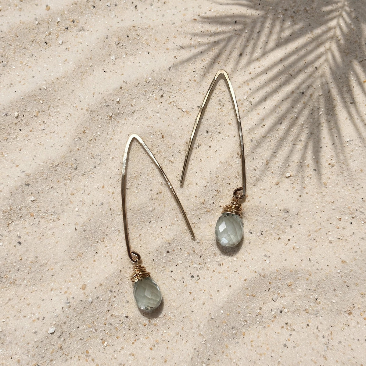 Mystic Green Amethyst Threader Earrings in 14k gold fill, styled on pale sand at the beach
