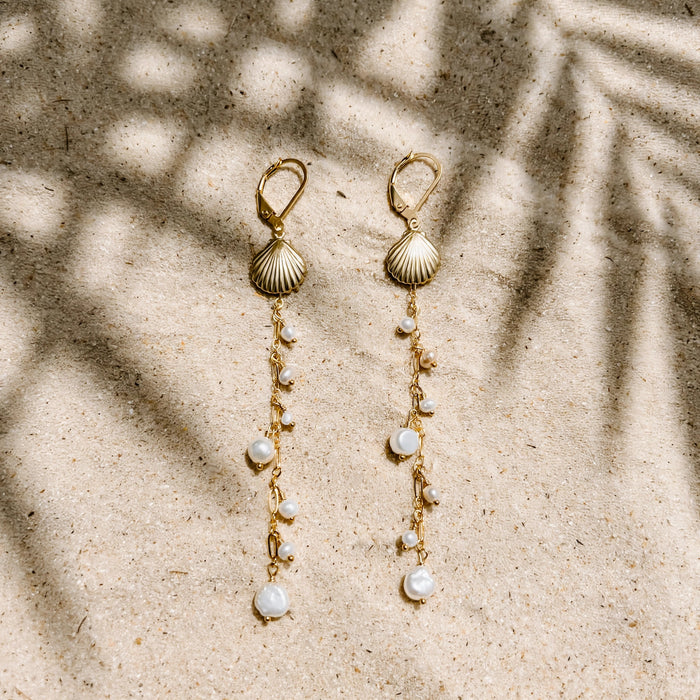 Pearl Beach Earrings in 14k gold fill, styled on pale sand at the beach