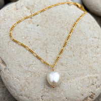 Pearl Drift Necklace in 14k gold fill, styled on pale sand at the beach
