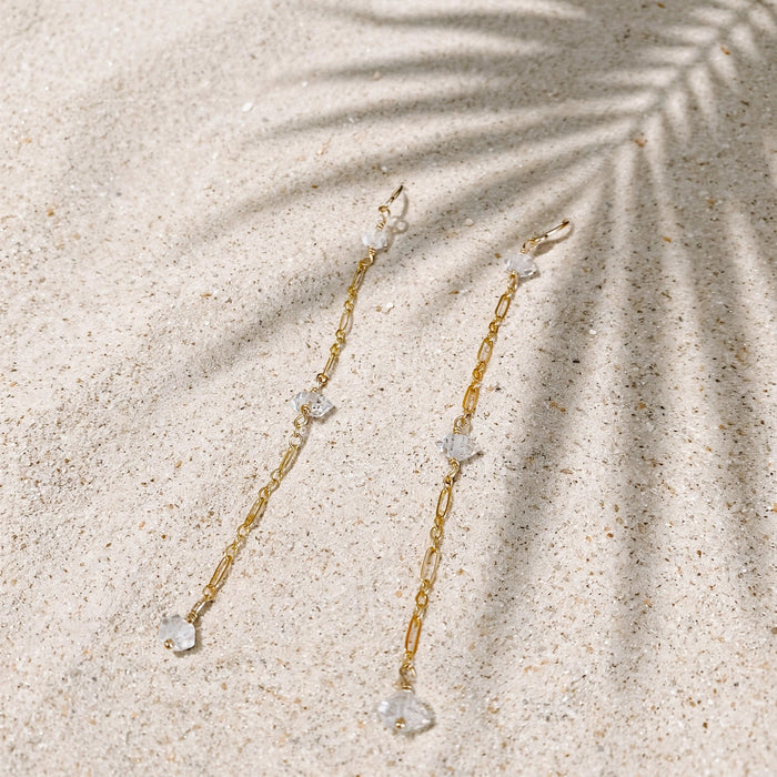 Rain Drop Earrings in 14k gold fill, styled on pale sand at the beach