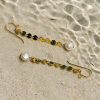 Sand Dollar Pearl Earrings in 14k gold fill, styled on pale sand at the beach
