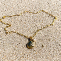 Shell Pendant Necklace in 14k gold fill, styled on pale sand at the beach