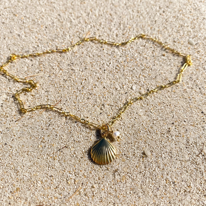 Shell Pendant Necklace in 14k gold fill, styled on pale sand at the beach