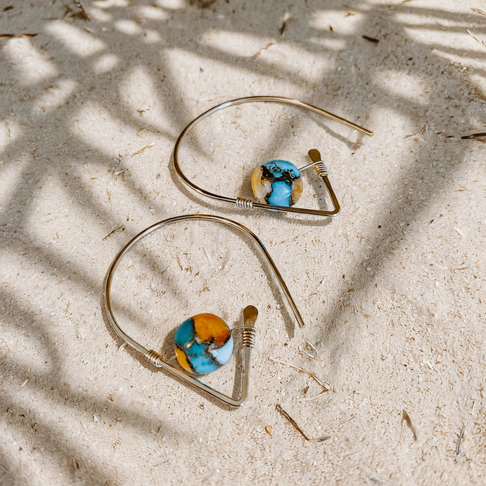 Spiny Oyster Turquoise Ear Threaders in 14k gold fill, styled on pale sand at the beach