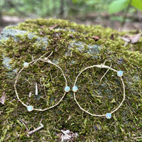 Stargazer Opal Hoop Earrings in 14k gold fill with opal beads on hammered hoops, styled on a mossy rock