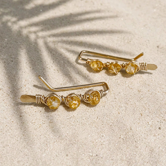 Stay Golden Ear Climbers in 14k gold fill, styled on pale sand at the beach