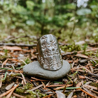 Stay Wild Shield Ring in sterling silver with hand-stamped star, moon and pine trees, styled on a stone