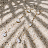Vahine Pearl Earrings in 14k gold fill, styled on pale sand at the beach